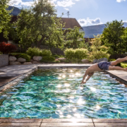 Timberra Naturpool mit klarem Wasser und Beckenwänden aus Holz